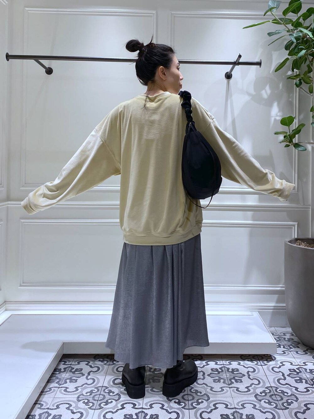 ブラック系のブーツ、ブラック系のショルダーバッグ、グレー系のスカートを着用したレディースの冬コーディネートの5枚目の写真