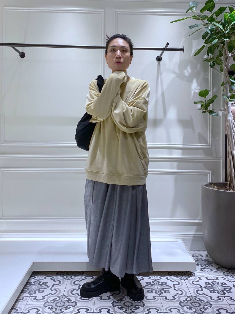 ブラック系のブーツ、ブラック系のショルダーバッグ、グレー系のスカートを着用したレディースの冬コーディネートの2枚目の写真