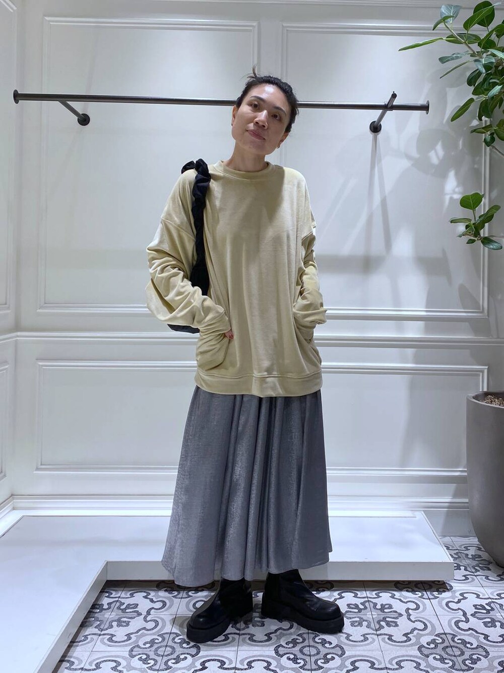 ブラック系のブーツ、ブラック系のショルダーバッグ、グレー系のスカートを着用したレディースの冬コーディネートの4枚目の写真