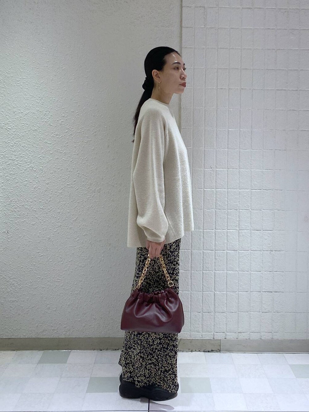 ホワイト系のニット/セーター、レッド系のショルダーバッグ、ブラック系のスカートを着用したレディースの冬コーディネートの3枚目の写真