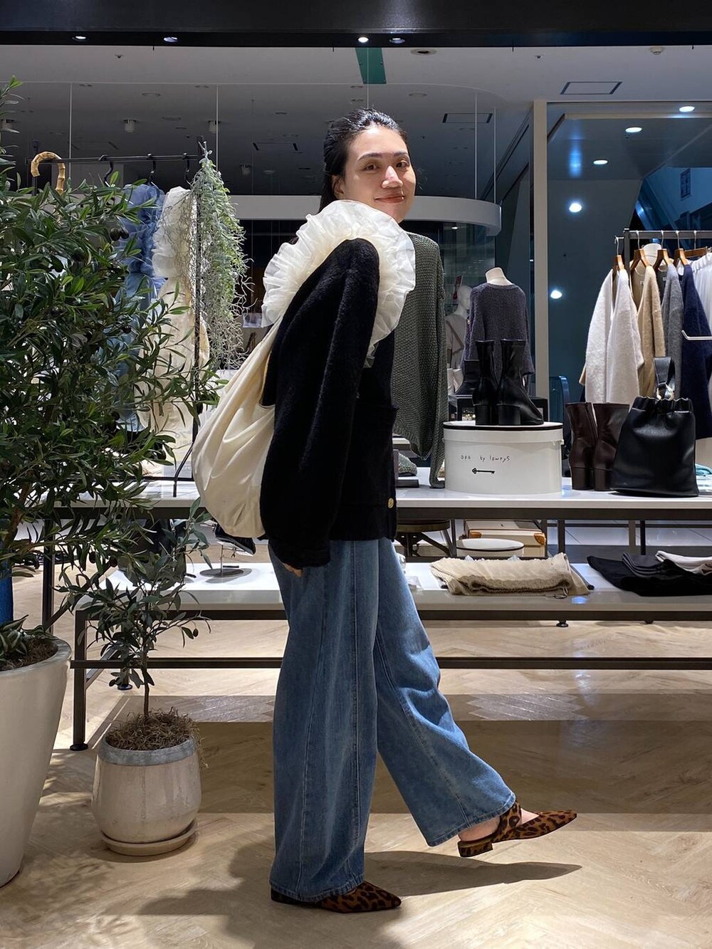 ブラック系のカーディガン/ボレロ、ホワイト系のショルダーバッグ、ブルー系のデニムパンツを着用したレディースの秋コーディネートの4枚目の写真