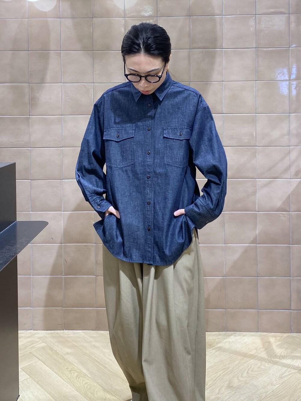 ベージュ系のスラックス、ブルー系のシャツ/ブラウスを着用したレディースの冬コーディネートの2枚目の写真