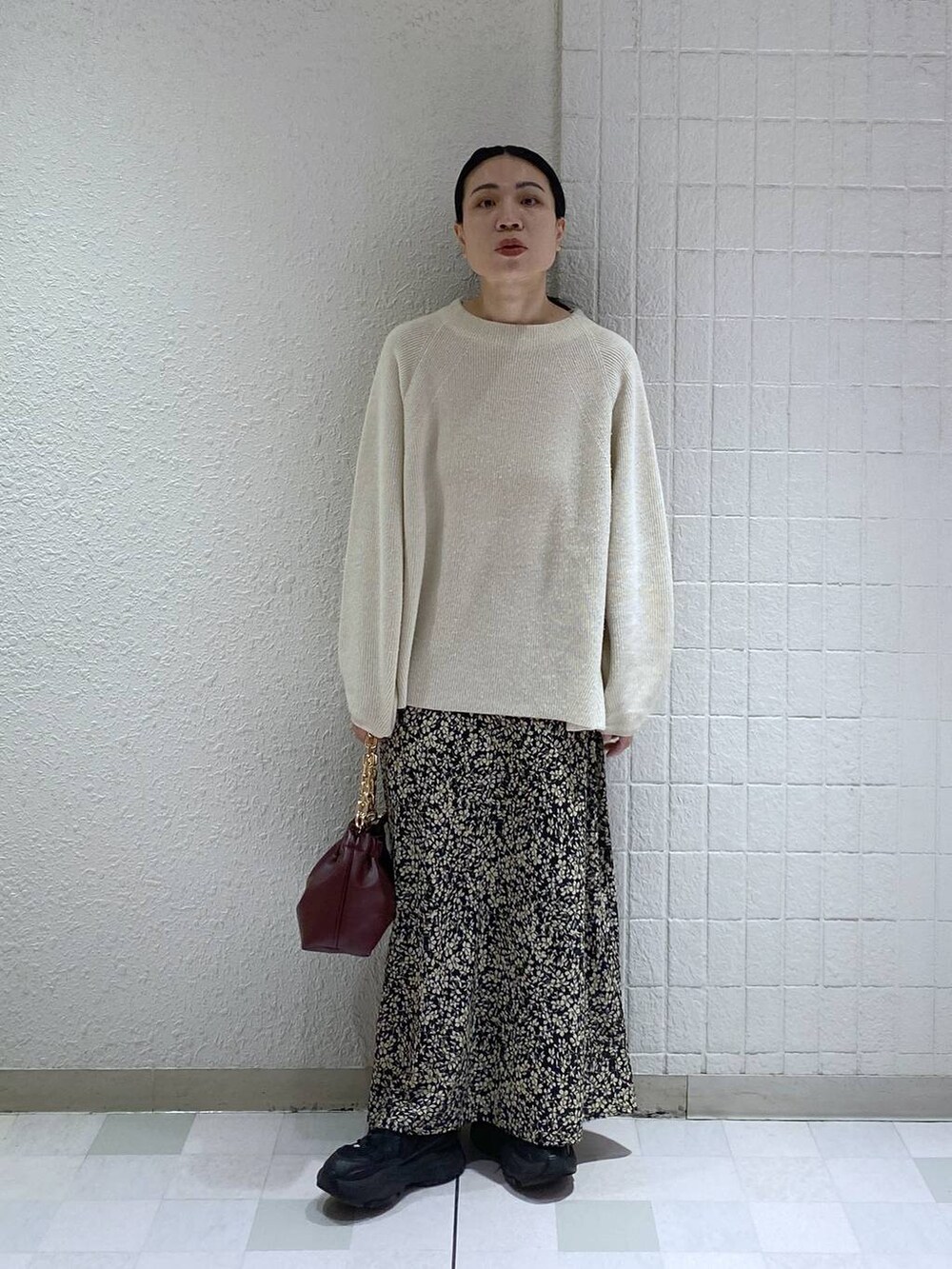 ホワイト系のニット/セーター、レッド系のショルダーバッグ、ブラック系のスカートを着用したレディースの冬コーディネートの2枚目の写真