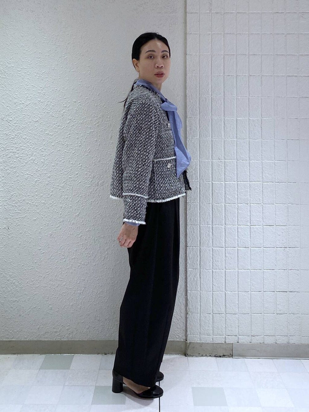 ブラック系のスラックス、ブルー系のシャツ/ブラウス、ブラック系のノーカラージャケットを着用したレディースの冬コーディネートの3枚目の写真