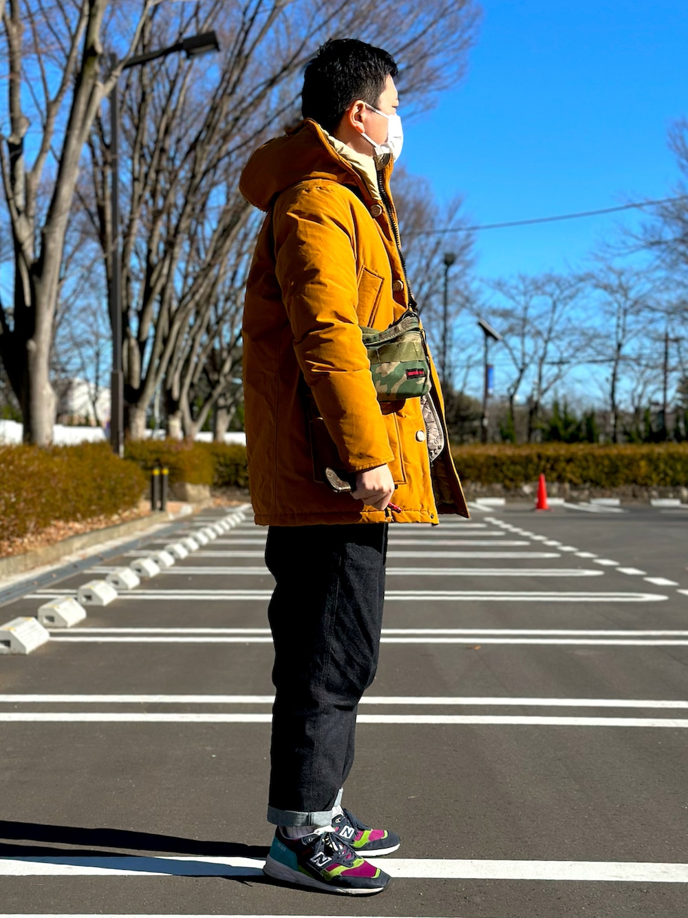 オレンジ系のダウンジャケット/コート、ベージュ系のダウンベスト、ブルー系のその他パンツを着用したメンズの冬コーディネートの2枚目の写真