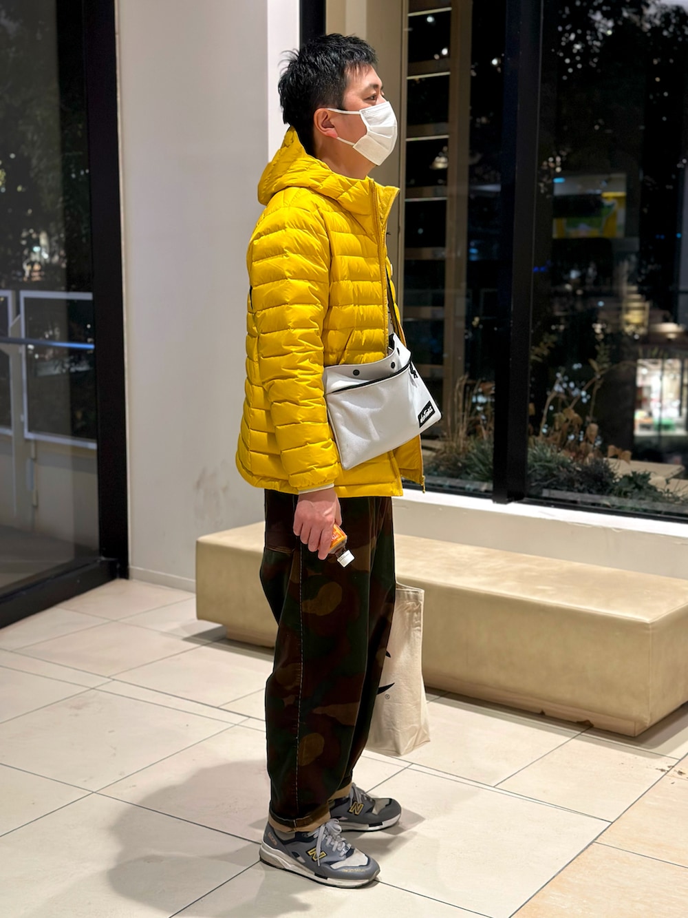 その他のパンツ、イエロー系のダウンジャケット/コート、グレー系のショルダーバッグを着用したメンズの冬コーディネートの2枚目の写真