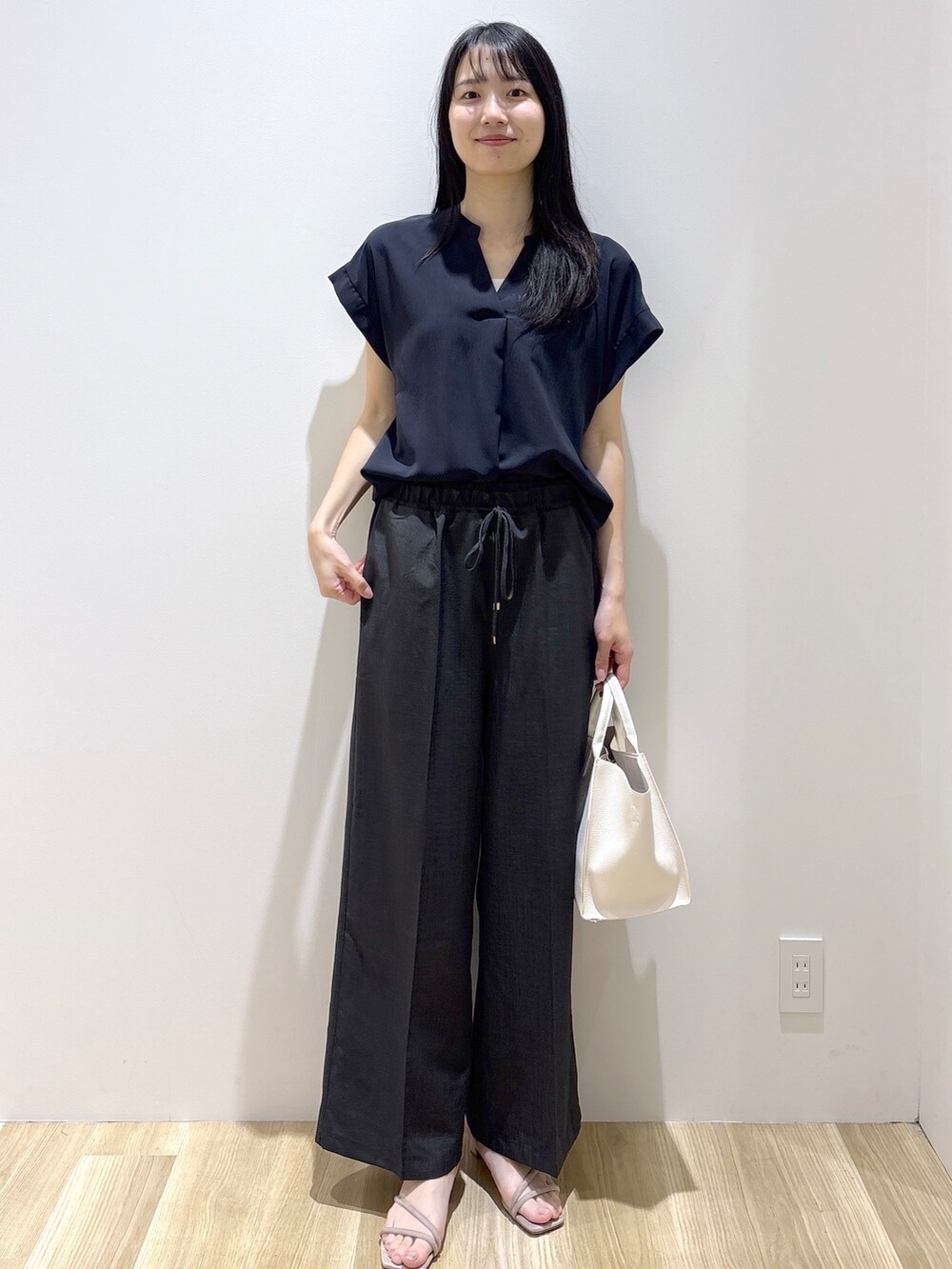ブラック系のシャツ/ブラウス、グレー系のその他パンツ、ホワイト系のショルダーバッグを着用したレディースの夏コーディネートの9枚目の写真