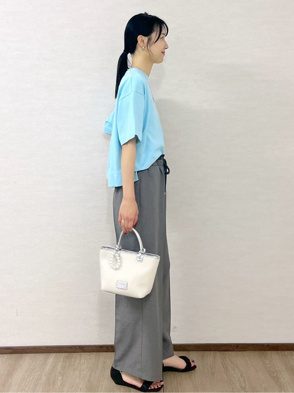 ブルー系のTシャツ/カットソー、グレー系のその他パンツ、シルバー系のトートバッグを着用したレディースの夏コーディネートの6枚目の写真