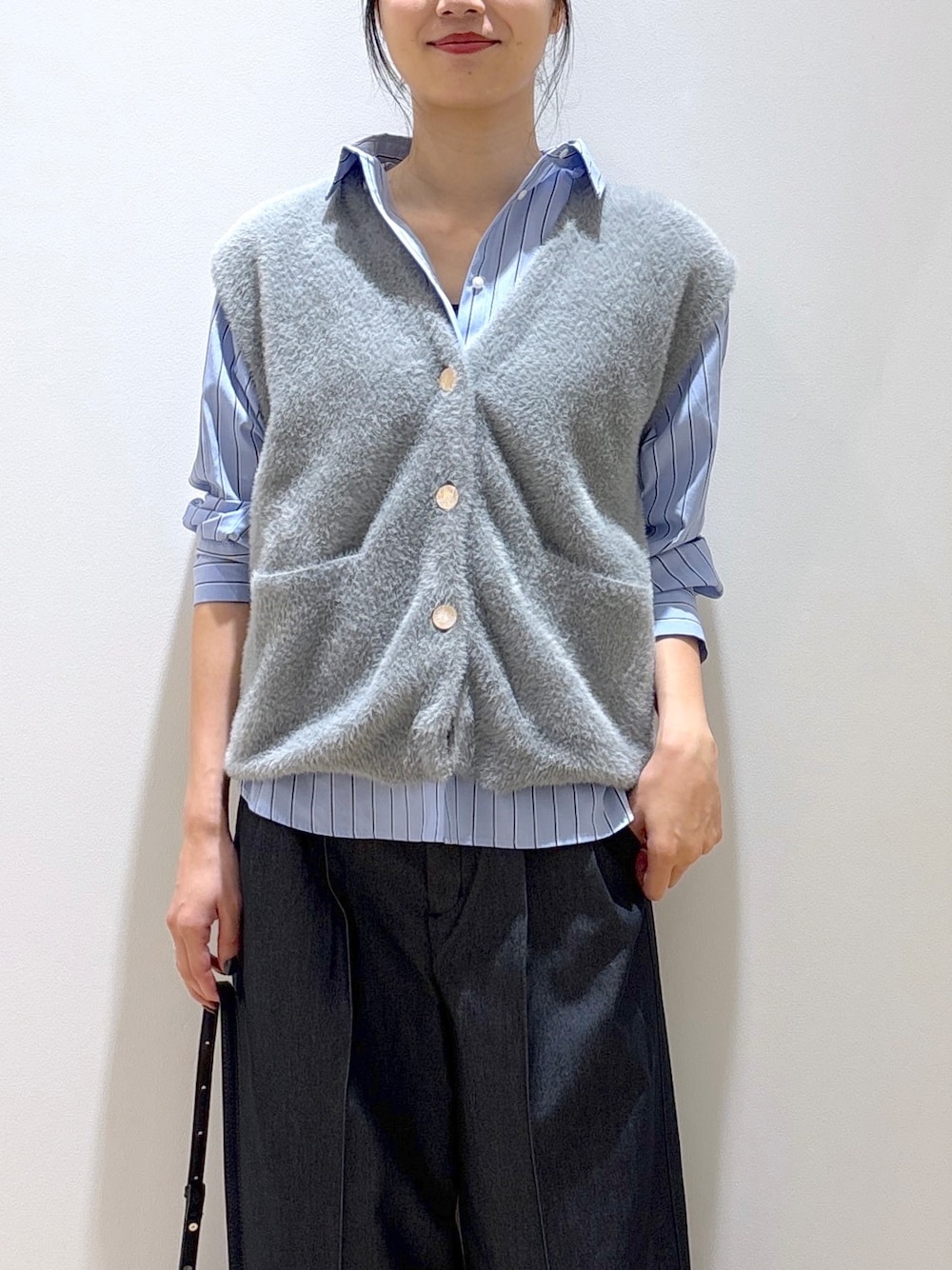 グレー系のニット/セーター、ブラック系のその他パンツ、ブラック系のショルダーバッグを着用したレディースの秋コーディネートの6枚目の写真