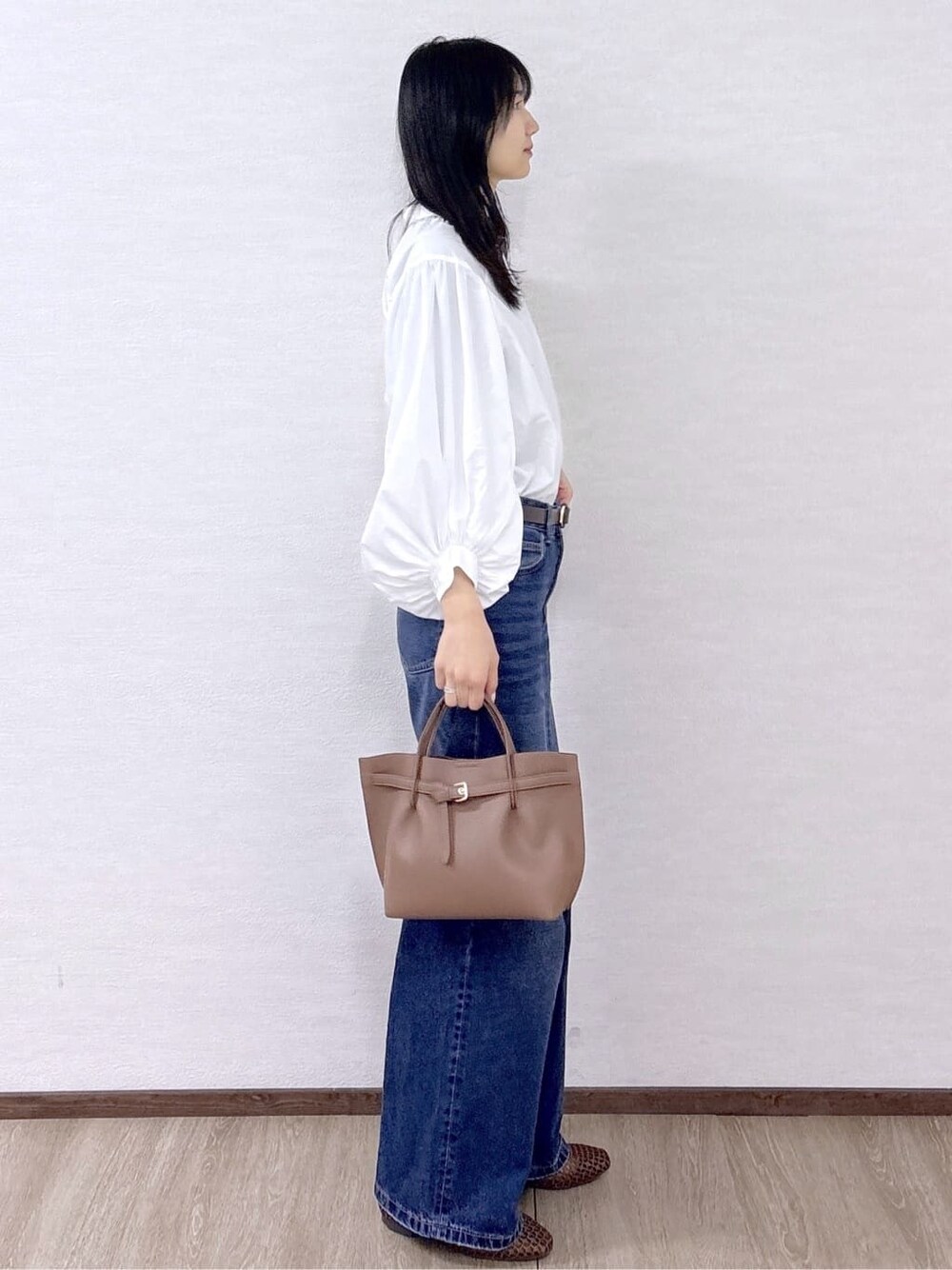 ホワイト系のシャツ/ブラウス、ブルー系のデニムパンツ、ブラウン系のトートバッグを着用したレディースの春コーディネートの5枚目の写真