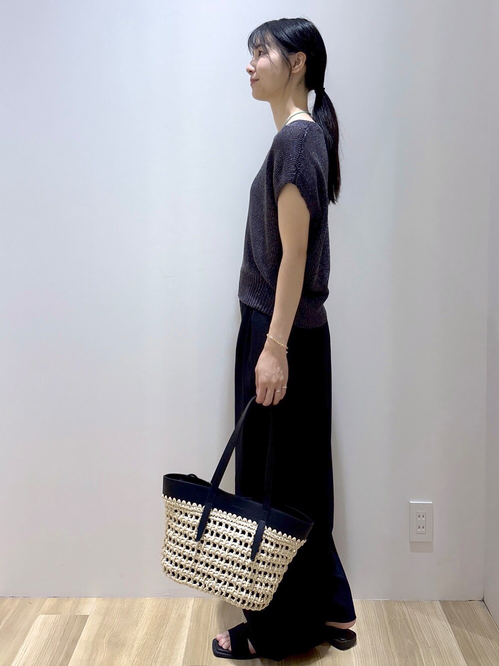 グレー系のニット/セーター、ブラック系のその他パンツ、ブラック系のトートバッグを着用したレディースの夏コーディネートの3枚目の写真
