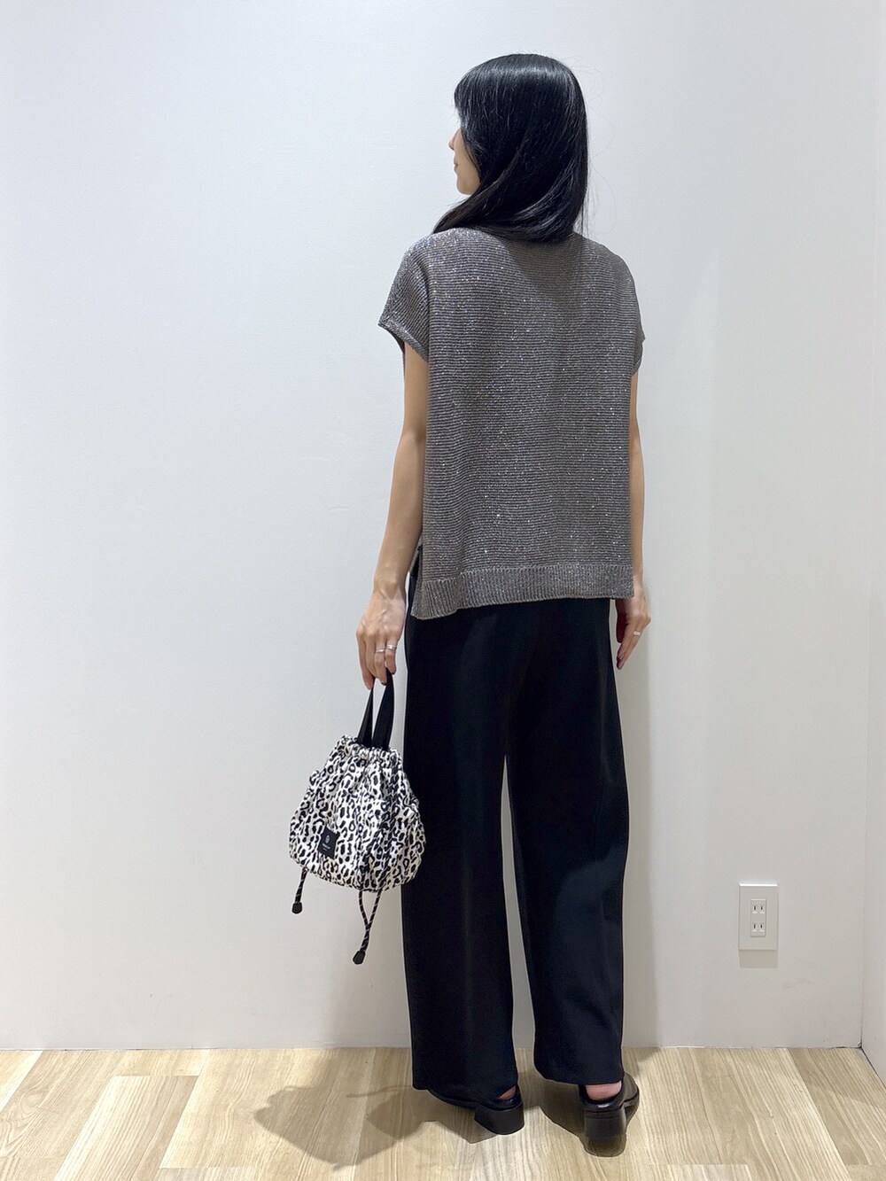 グレー系のニット/セーター、ブラック系のその他パンツ、ベージュ系のショルダーバッグを着用したレディースの夏コーディネートの4枚目の写真