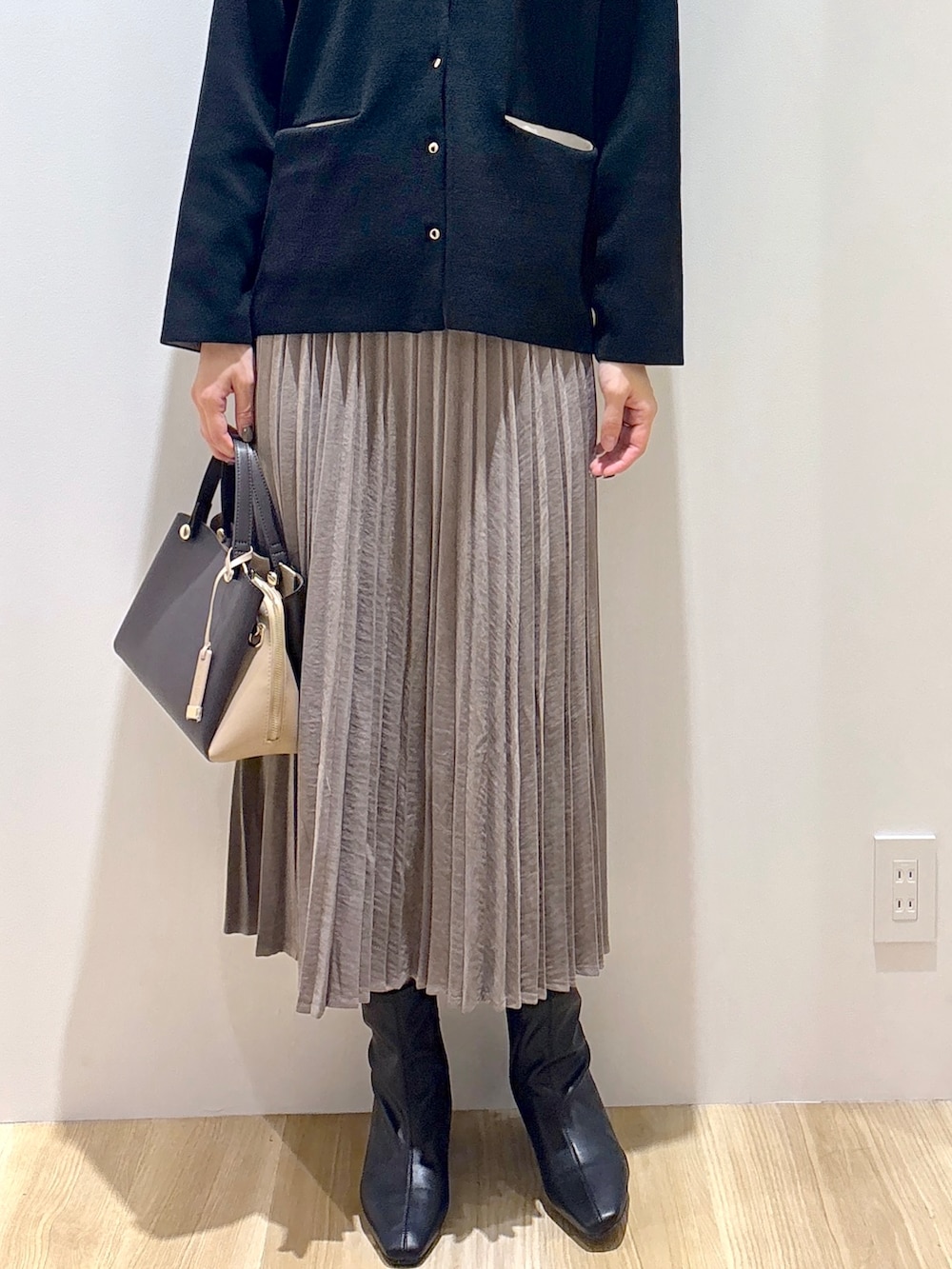 ブラック系のカーディガン/ボレロ、ブラウン系のスカート、ブラウン系のボストンバッグを着用したレディースの秋コーディネートの7枚目の写真