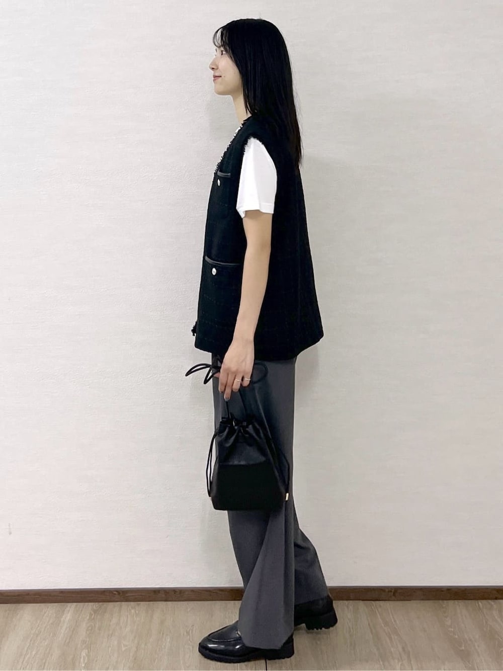 ブラック系のベスト、ホワイト系のTシャツ/カットソー、グレー系のその他パンツを着用したレディースの秋コーディネートの3枚目の写真