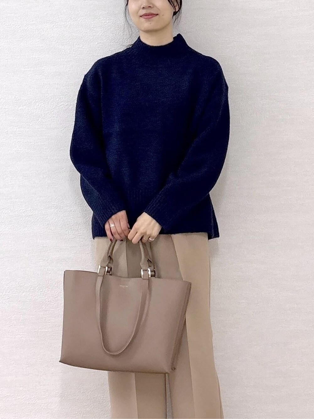 ブルー系のニット/セーター、ベージュ系のその他パンツ、ベージュ系のトートバッグを着用したレディースの冬コーディネートの6枚目の写真