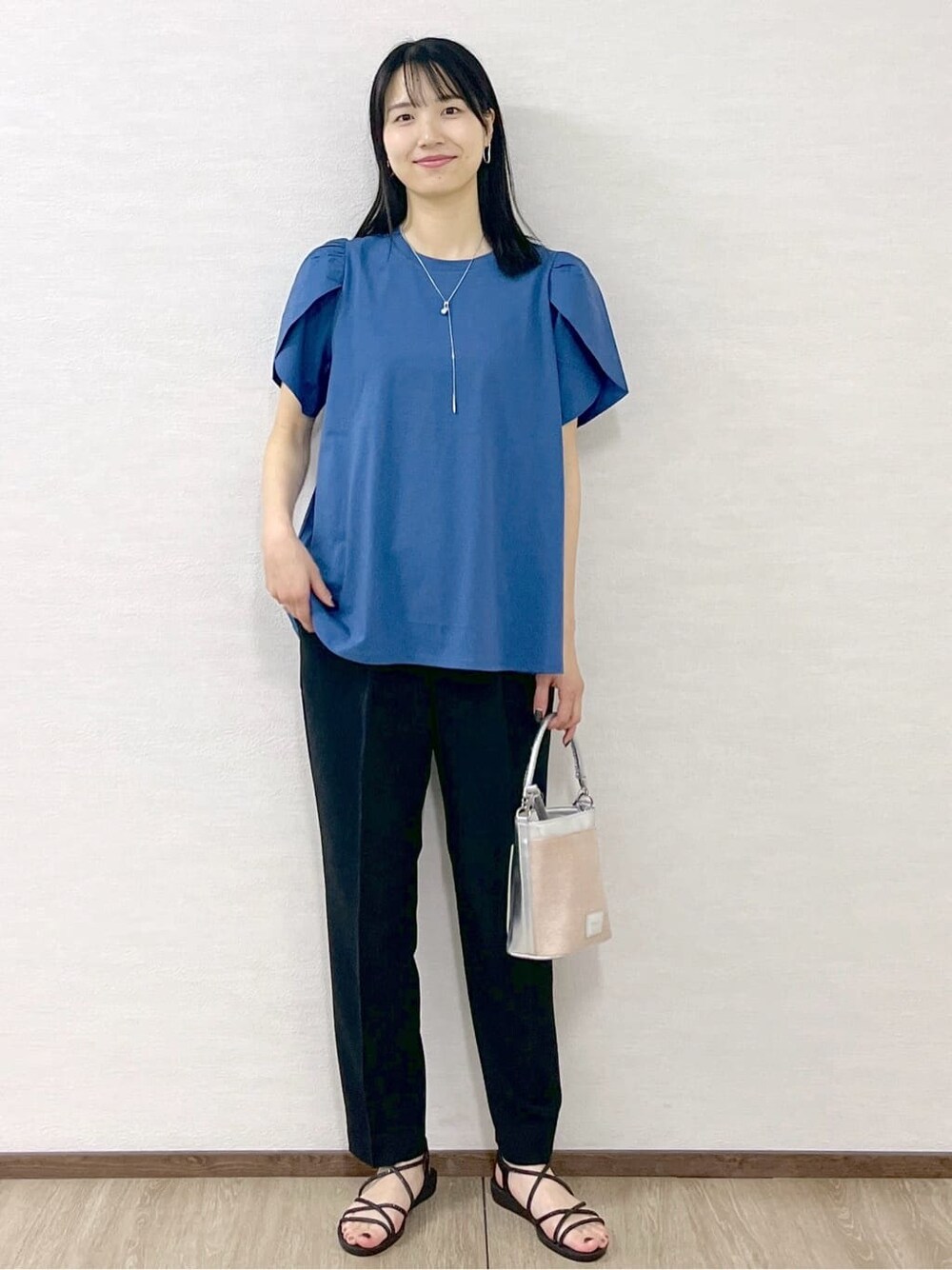 ブルー系のTシャツ/カットソー、ブラック系のその他パンツ、シルバー系のショルダーバッグを着用したレディースの春コーディネートの9枚目の写真