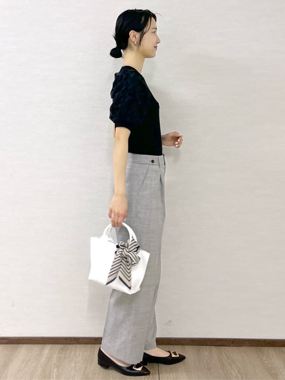 ブラック系のTシャツ/カットソー、グレー系のその他パンツ、ホワイト系のトートバッグを着用したレディースの春コーディネートの6枚目の写真