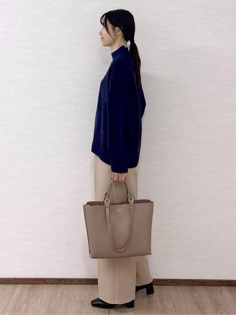 ブルー系のニット/セーター、ベージュ系のその他パンツ、ベージュ系のトートバッグを着用したレディースの冬コーディネートの3枚目の写真