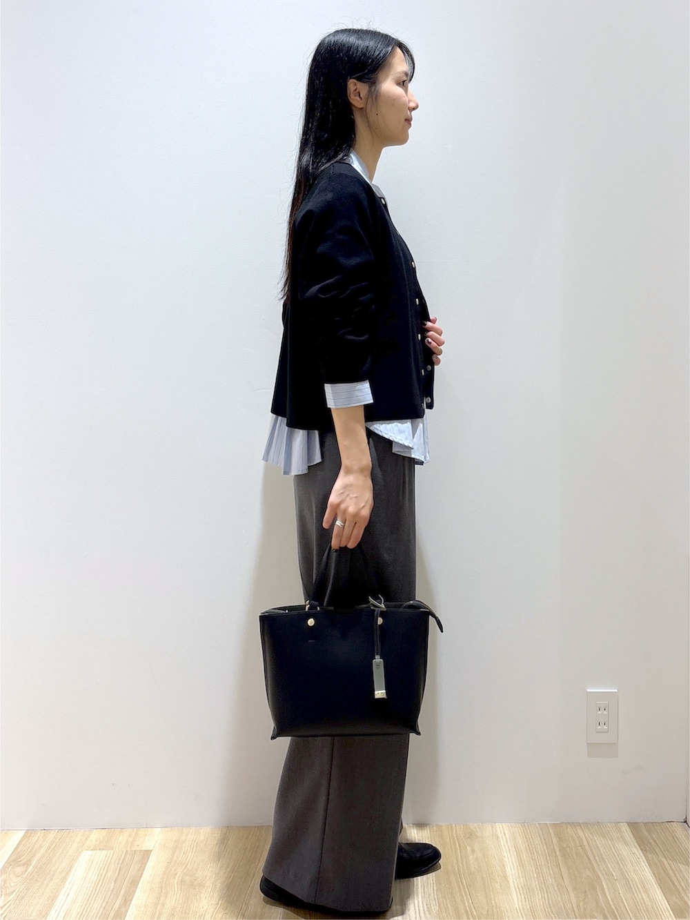 ブラック系のカーディガン/ボレロ、ブルー系のシャツ/ブラウス、グレー系のその他パンツを着用したレディースの秋コーディネートの5枚目の写真