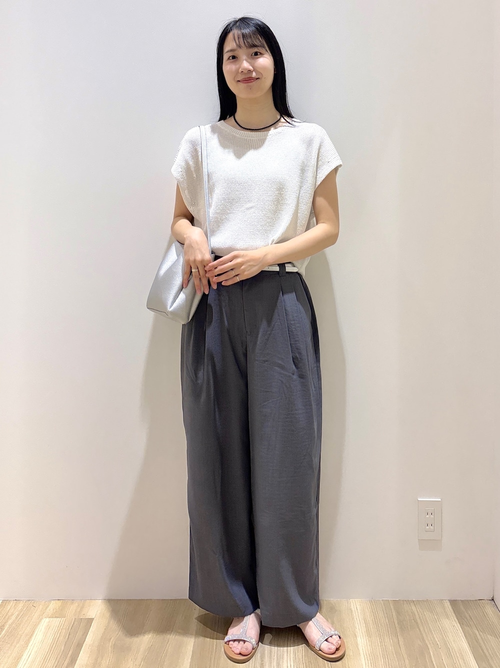 ホワイト系のニット/セーター、グレー系のその他パンツ、シルバー系のショルダーバッグを着用したレディースの夏コーディネートの6枚目の写真