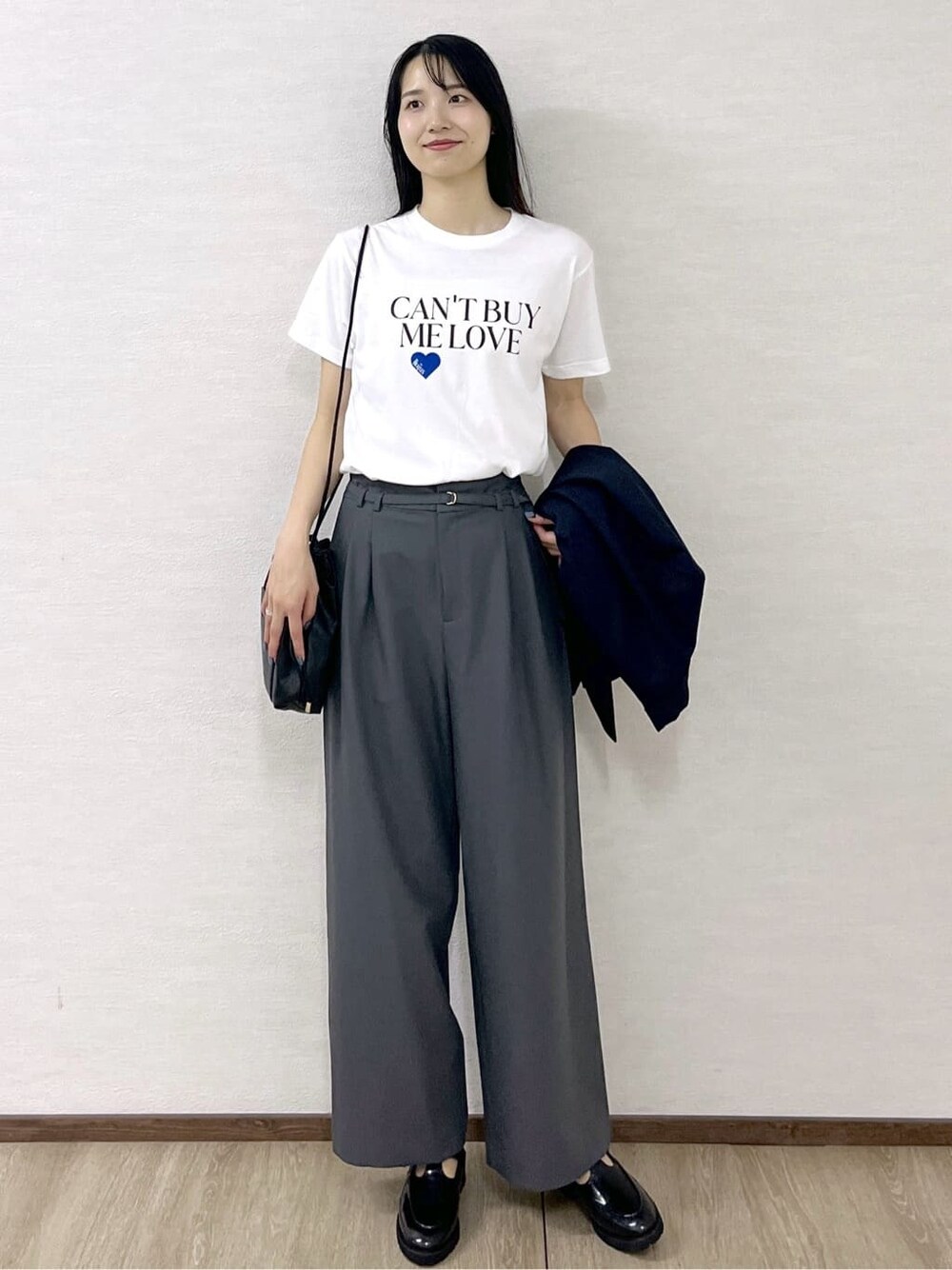 ホワイト系のTシャツ/カットソー、グレー系のその他パンツ、ブラック系のショルダーバッグを着用したレディースの秋コーディネートの2枚目の写真