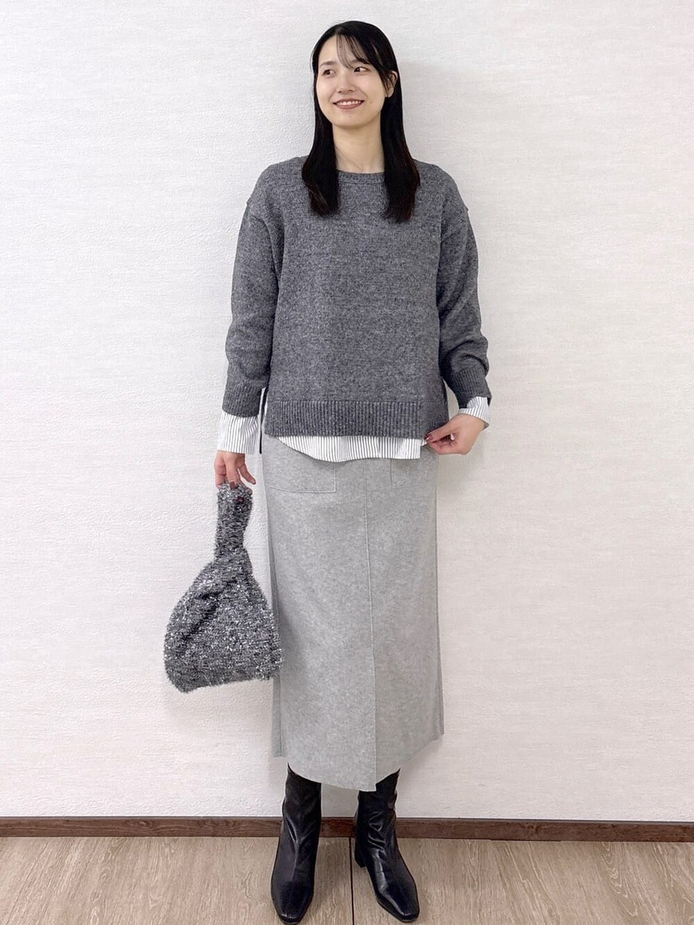 ブラック系のノーカラーコート、グレー系のニット/セーター、ホワイト系のTシャツ/カットソーを着用したレディースの冬コーディネートの9枚目の写真