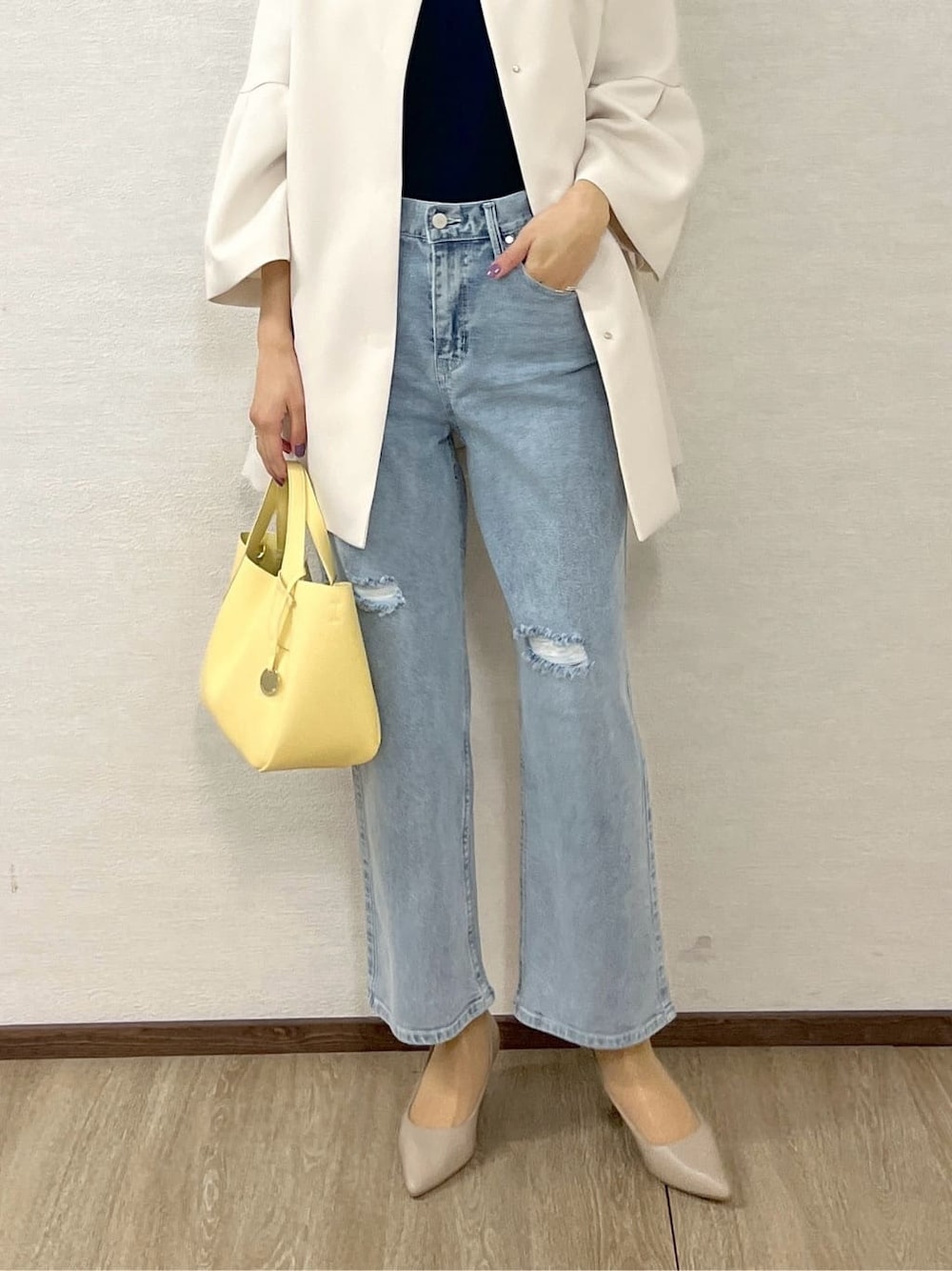 ホワイト系のノーカラーコート、ブルー系のニット/セーター、ブルー系のその他パンツを着用したレディースの冬コーディネートの7枚目の写真