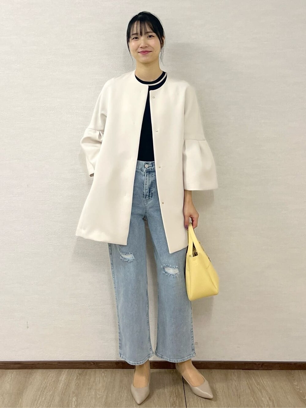 ホワイト系のノーカラーコート、ブルー系のニット/セーター、ブルー系のその他パンツを着用したレディースの冬コーディネートの9枚目の写真