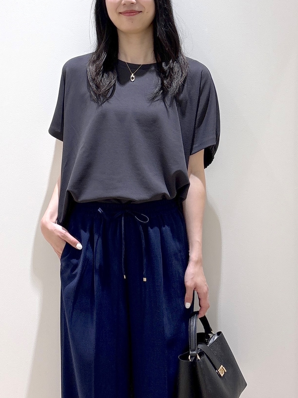 ブラック系のハンドバッグ、ベージュ系のショルダーバッグ、グレー系のTシャツ/カットソーを着用したレディースの春コーディネートの6枚目の写真