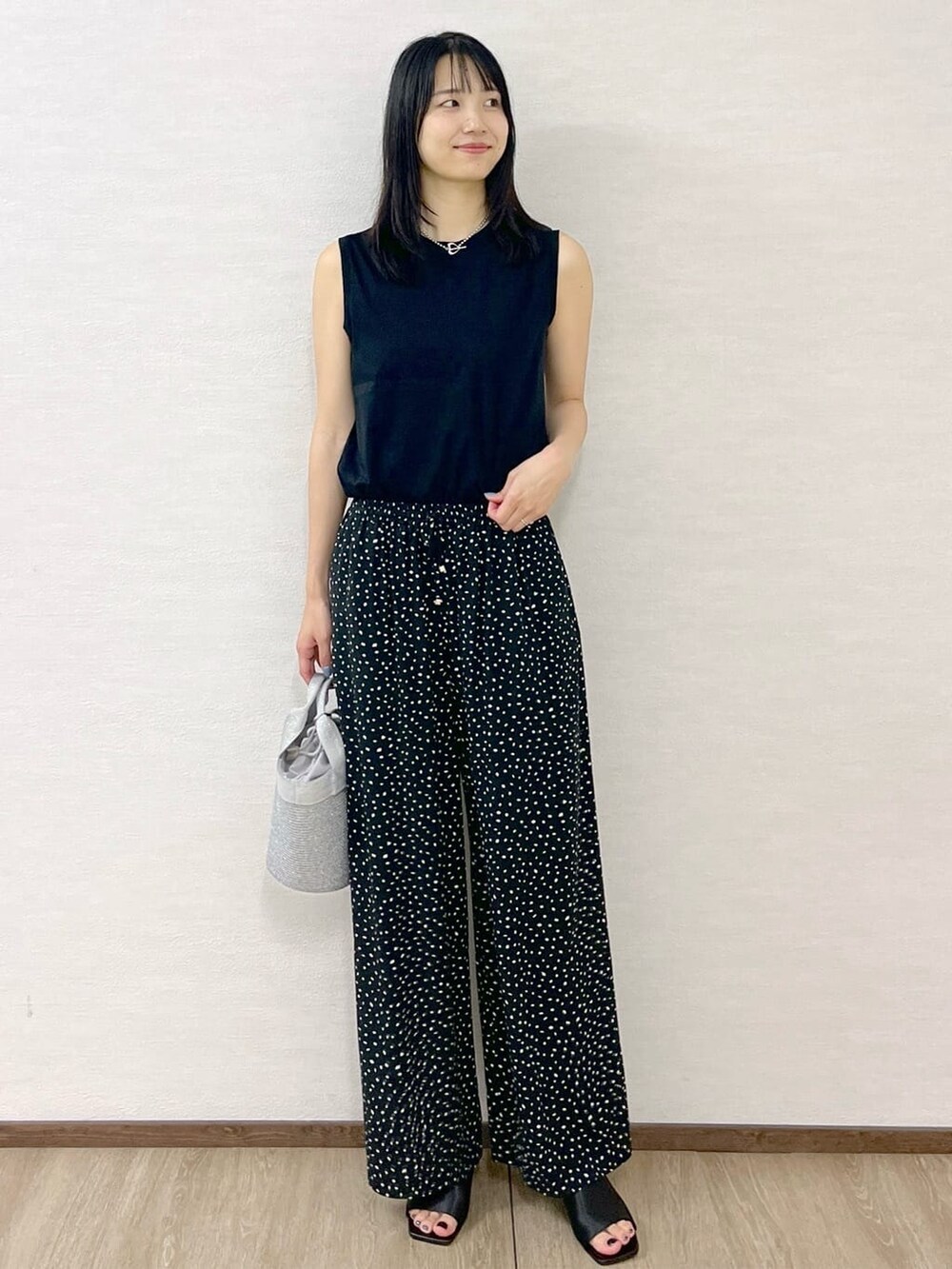 ブラック系のタンクトップ、ブラック系のその他パンツ、シルバー系のトートバッグを着用したレディースの夏コーディネートの2枚目の写真