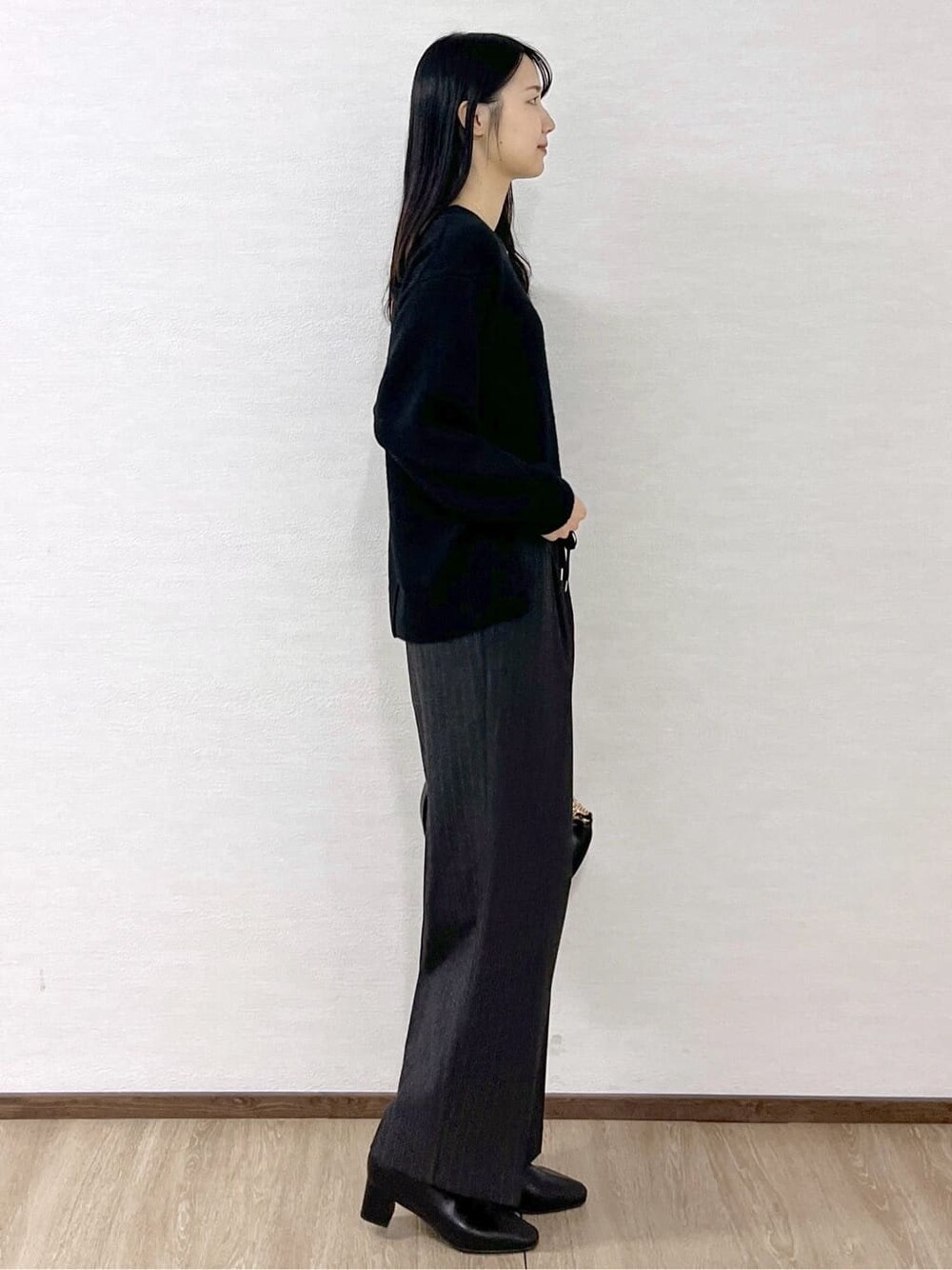 ブラック系のニット/セーター、グレー系のその他パンツ、ブラック系のハンドバッグを着用したレディースの冬コーディネートの5枚目の写真