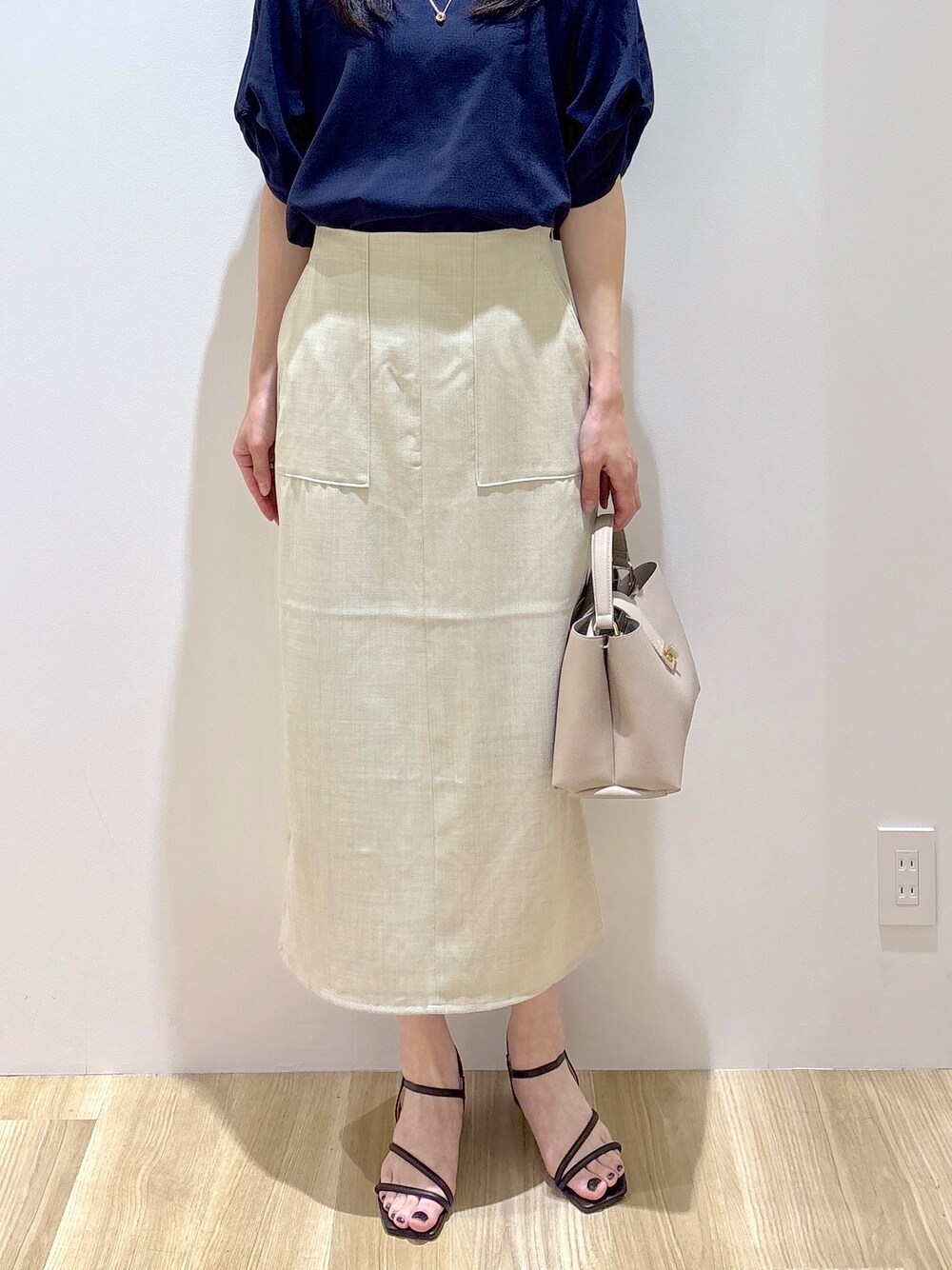 ブルー系のシャツ/ブラウス、ベージュ系のスカート、ベージュ系のハンドバッグを着用したレディースの夏コーディネートの7枚目の写真