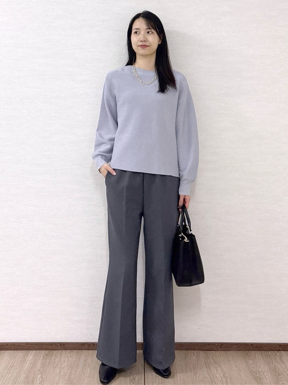 ブルー系のニット/セーター、グレー系のその他パンツ、ブラック系のトートバッグを着用したレディースの冬コーディネートの9枚目の写真