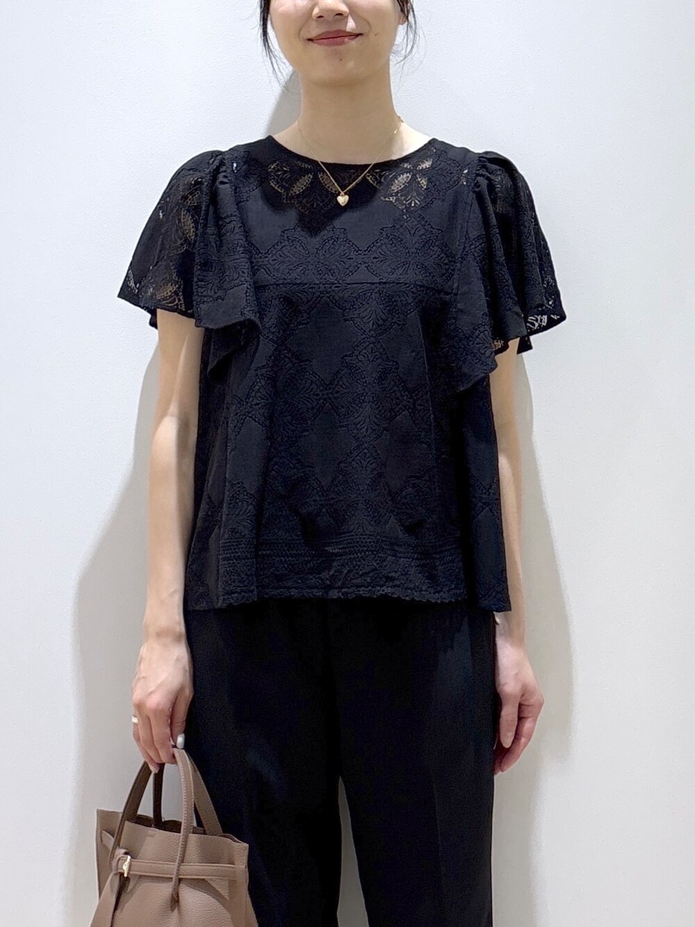 ブラック系のシャツ/ブラウス、ブラック系のその他パンツ、ブラウン系のトートバッグを着用したレディースの春コーディネートの6枚目の写真