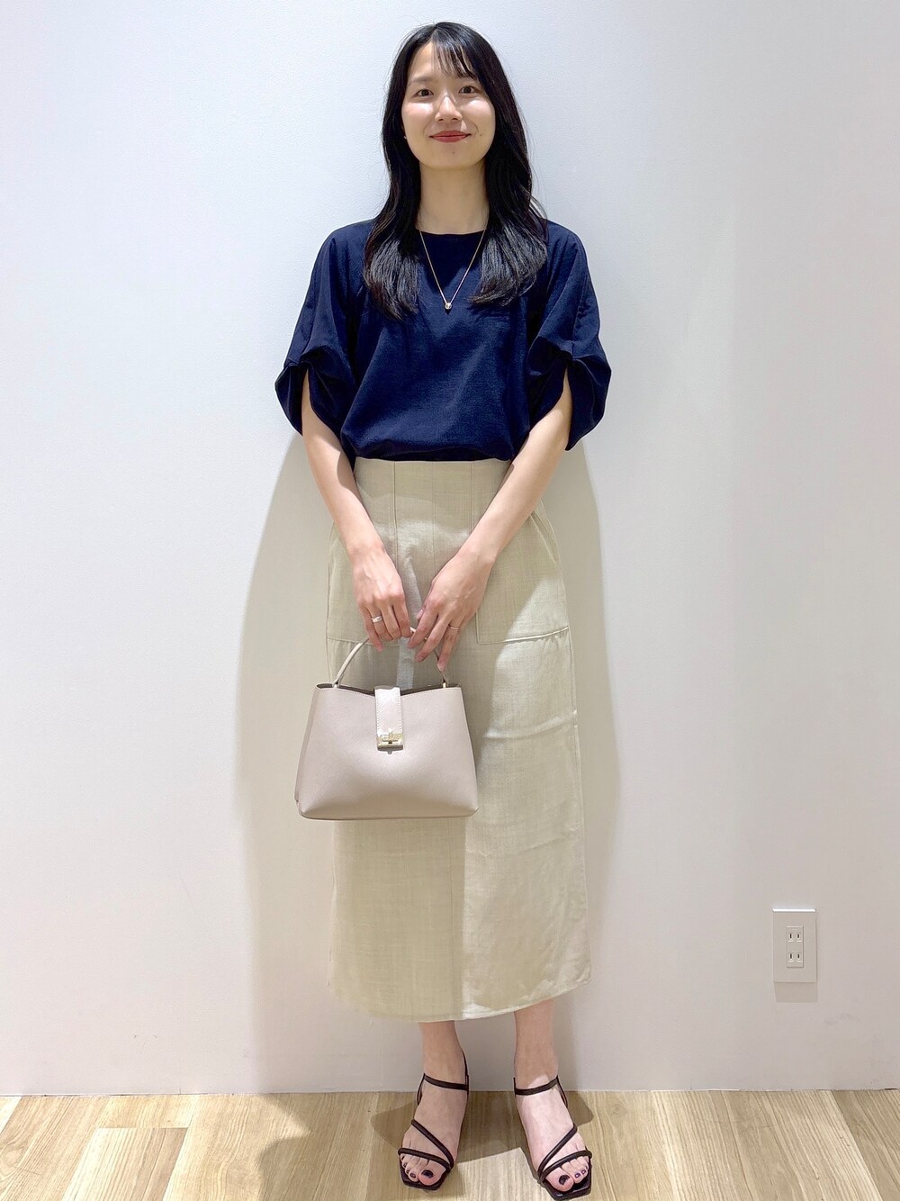 ブルー系のシャツ/ブラウス、ベージュ系のスカート、ベージュ系のハンドバッグを着用したレディースの夏コーディネートの8枚目の写真