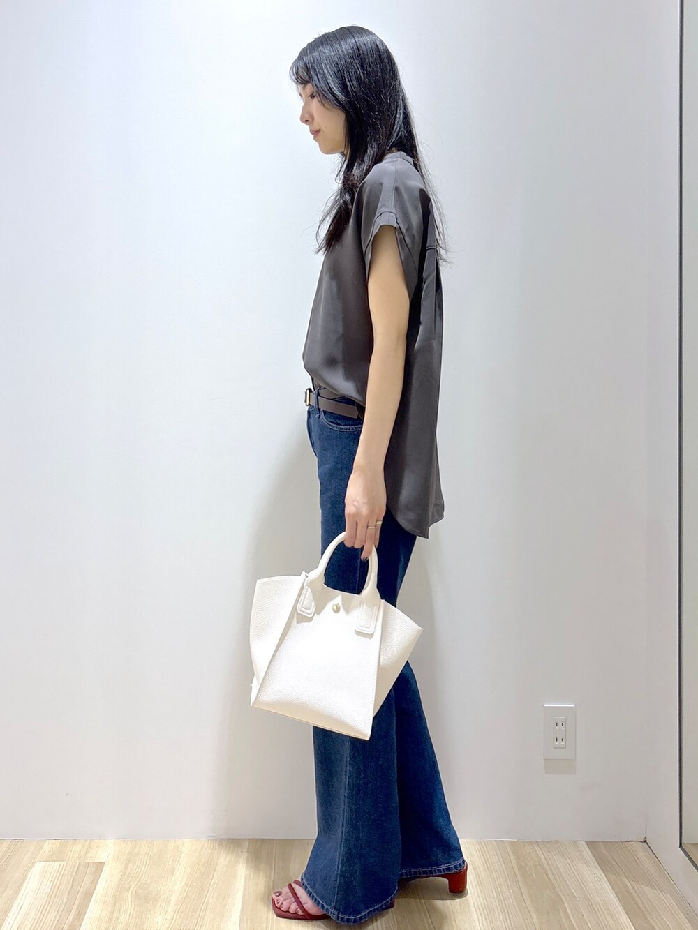 ブルー系のデニムパンツ、ホワイト系のショルダーバッグ、レッド系のサンダルを着用したレディースの夏コーディネートの3枚目の写真