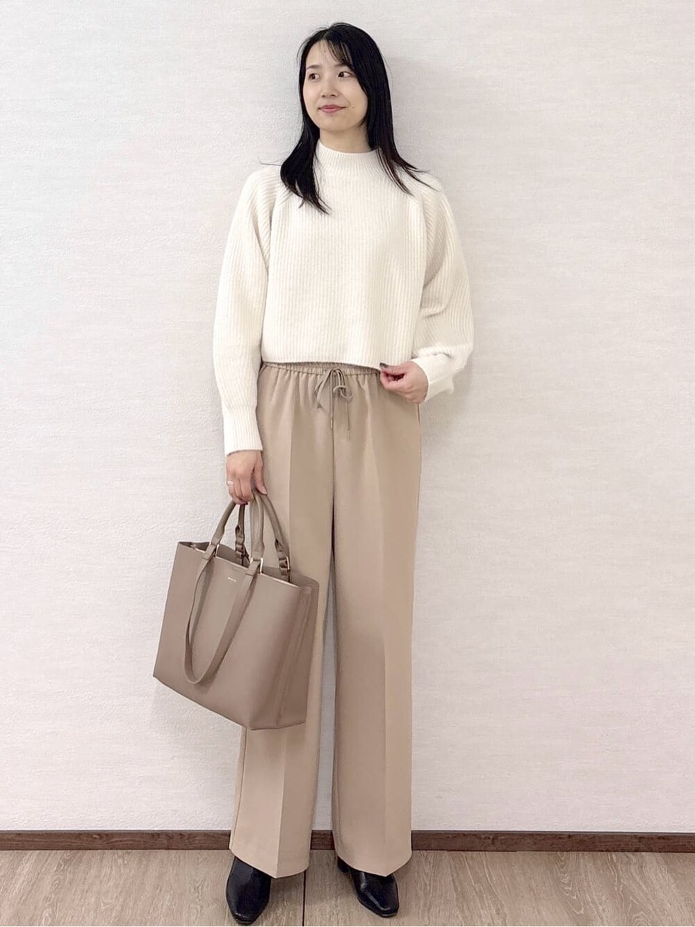 ホワイト系のニット/セーター、ベージュ系のその他パンツ、ベージュ系のトートバッグを着用したレディースの冬コーディネートの8枚目の写真