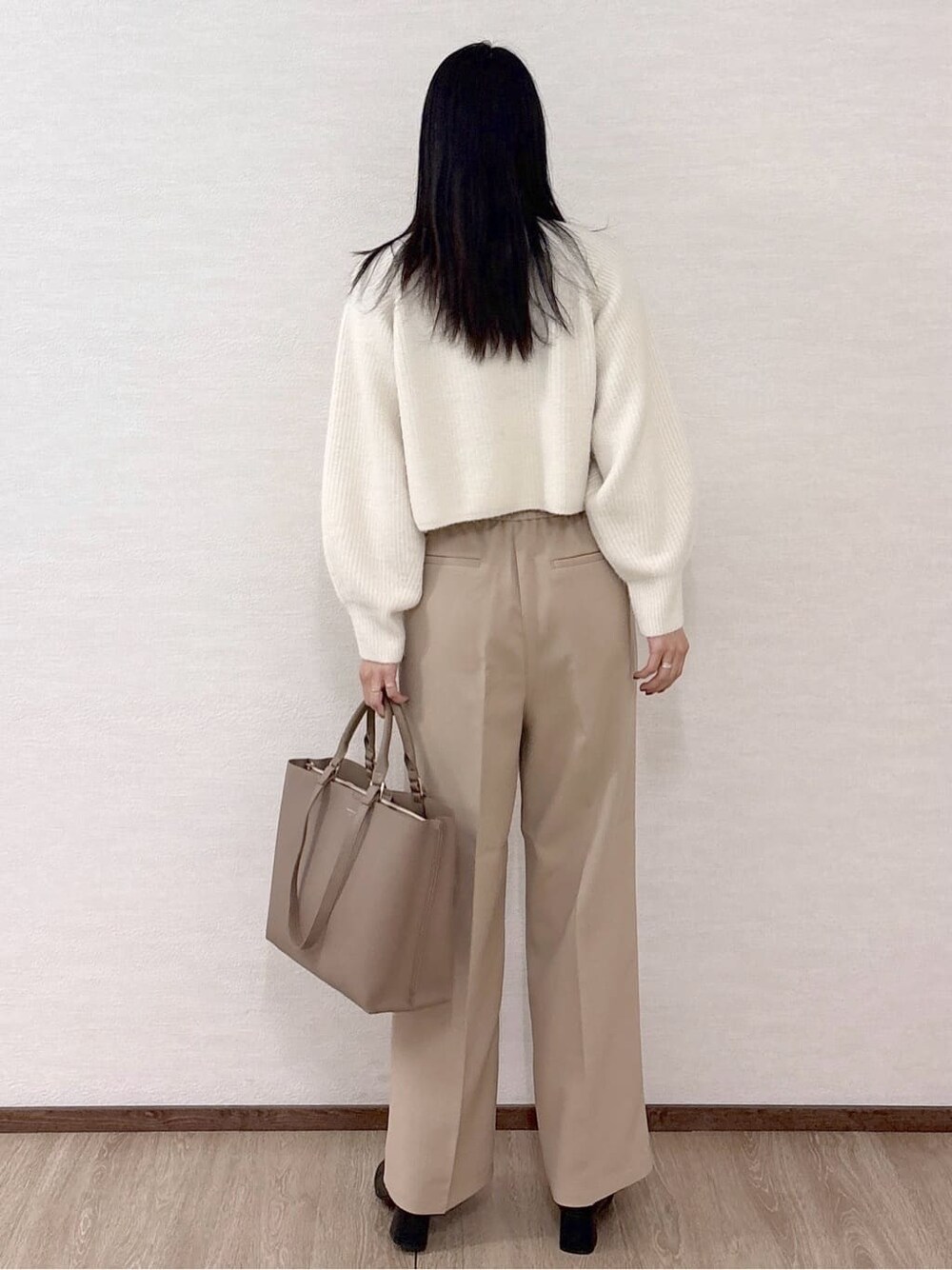 ホワイト系のニット/セーター、ベージュ系のその他パンツ、ベージュ系のトートバッグを着用したレディースの冬コーディネートの4枚目の写真