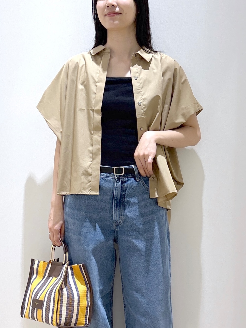 ベージュ系のシャツ/ブラウス、ブラック系のタンクトップ、ブルー系のデニムパンツを着用したレディースの夏コーディネートの7枚目の写真