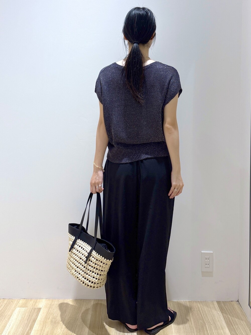 グレー系のニット/セーター、ブラック系のその他パンツ、ブラック系のトートバッグを着用したレディースの夏コーディネートの4枚目の写真