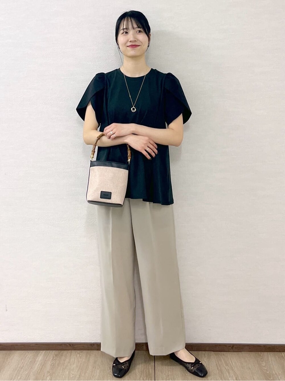 ブラック系のTシャツ/カットソー、ベージュ系のその他パンツ、ブラック系のショルダーバッグを着用したレディースの春コーディネートの3枚目の写真