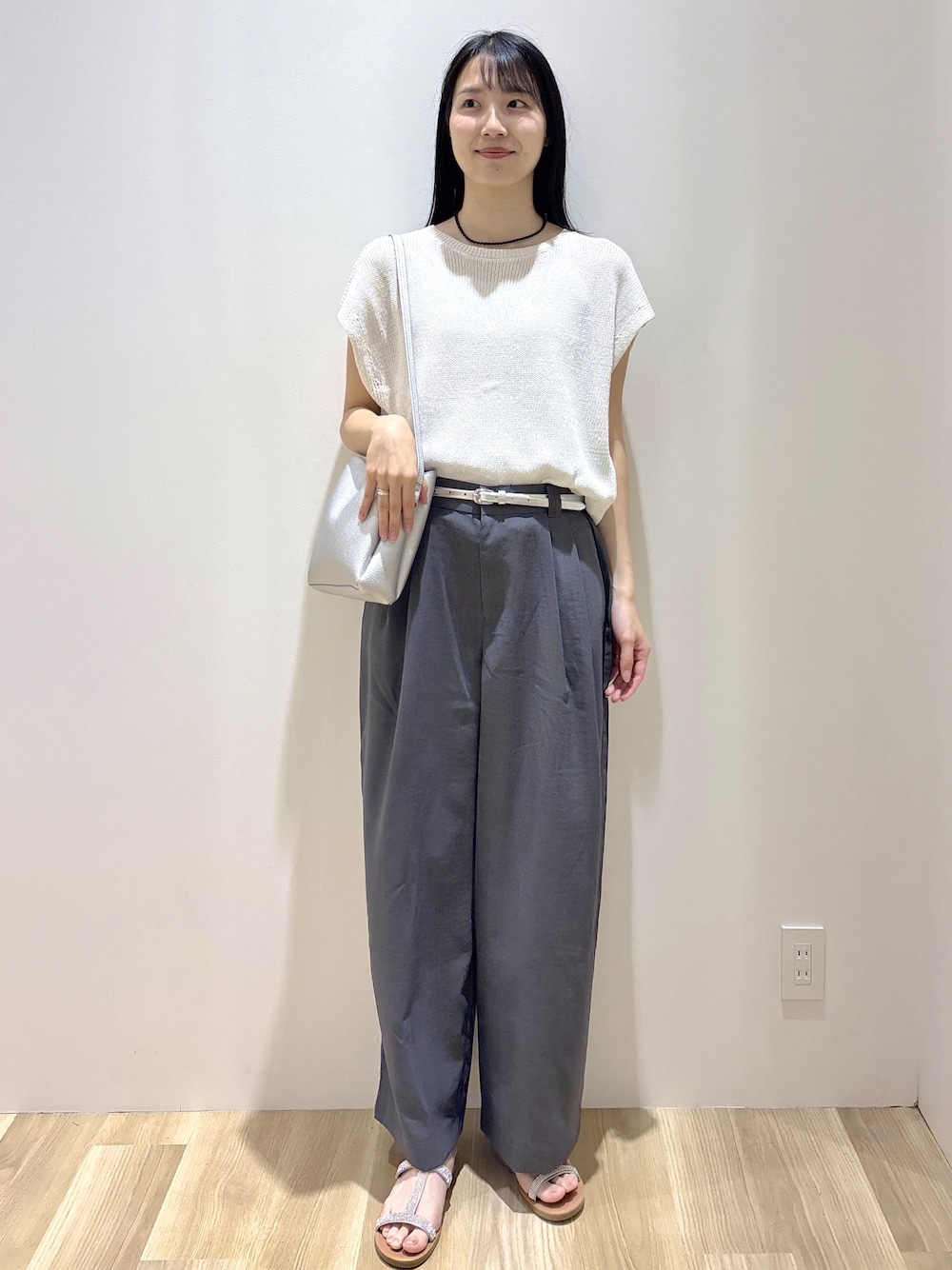 ホワイト系のニット/セーター、グレー系のその他パンツ、シルバー系のショルダーバッグを着用したレディースの夏コーディネートの2枚目の写真