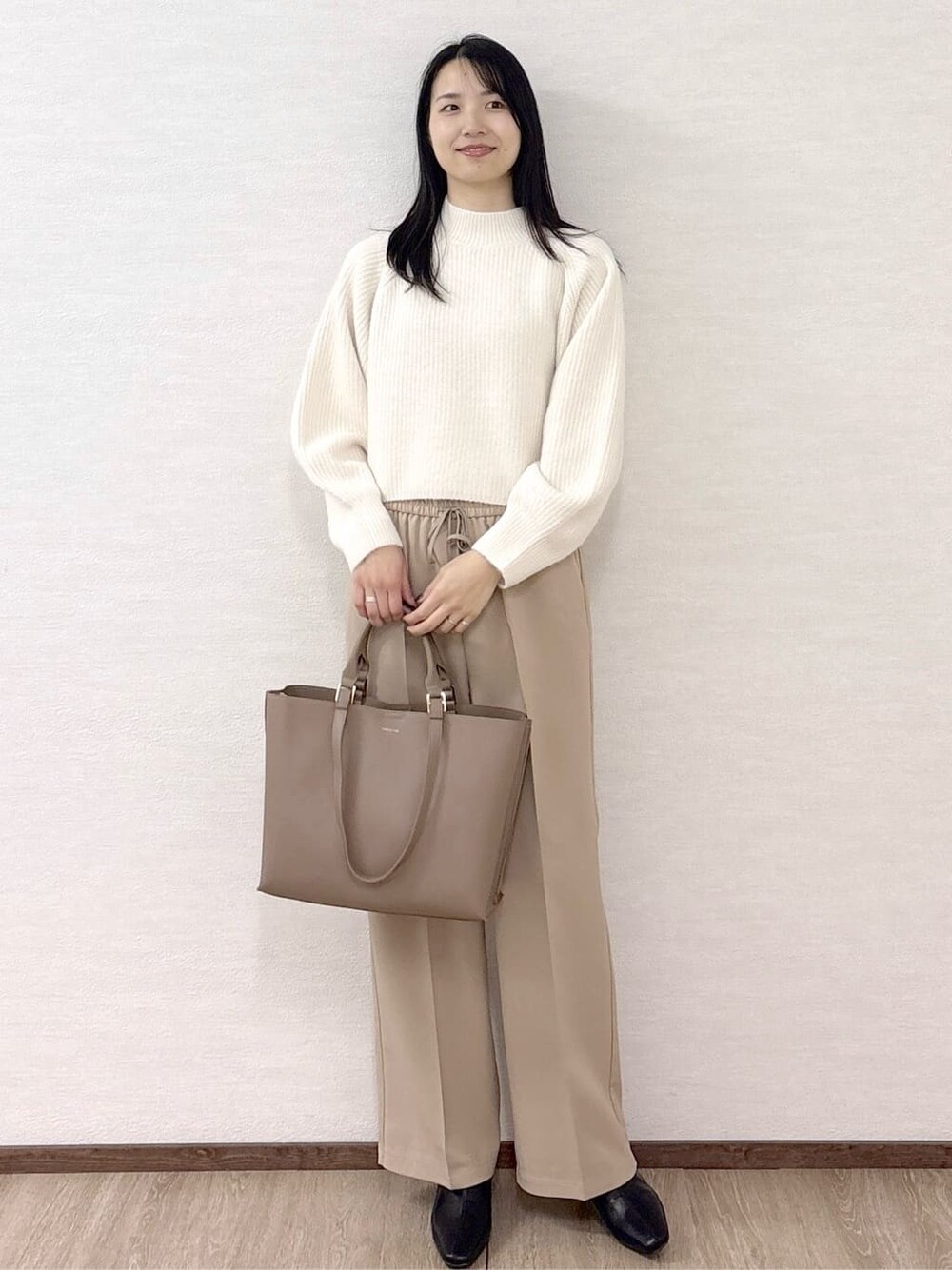 ホワイト系のニット/セーター、ベージュ系のその他パンツ、ベージュ系のトートバッグを着用したレディースの冬コーディネートの9枚目の写真