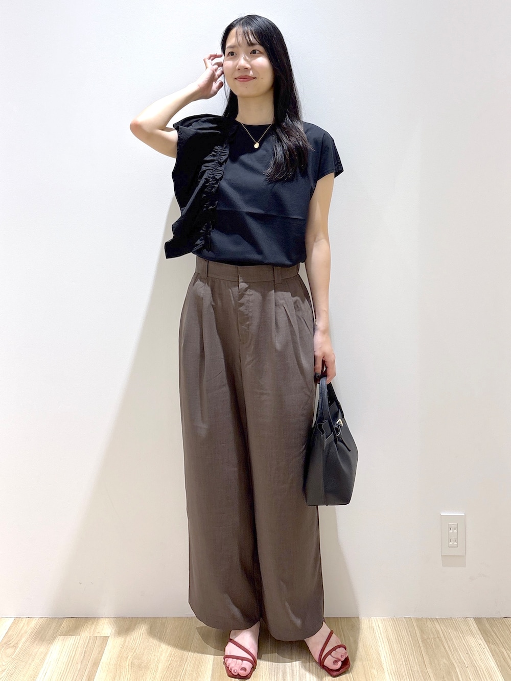 ブラック系のTシャツ/カットソー、ブラウン系のその他パンツ、ブラウン系のトートバッグを着用したレディースの夏コーディネートの2枚目の写真