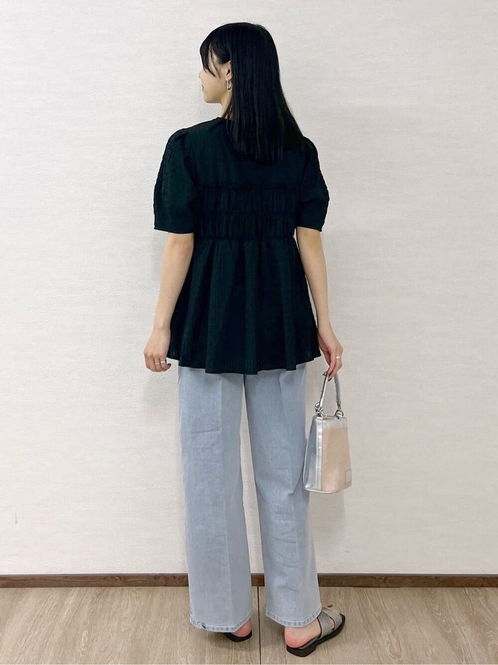 ブラック系のシャツ/ブラウス、ブルー系のデニムパンツ、シルバー系のショルダーバッグを着用したレディースの春コーディネートの6枚目の写真