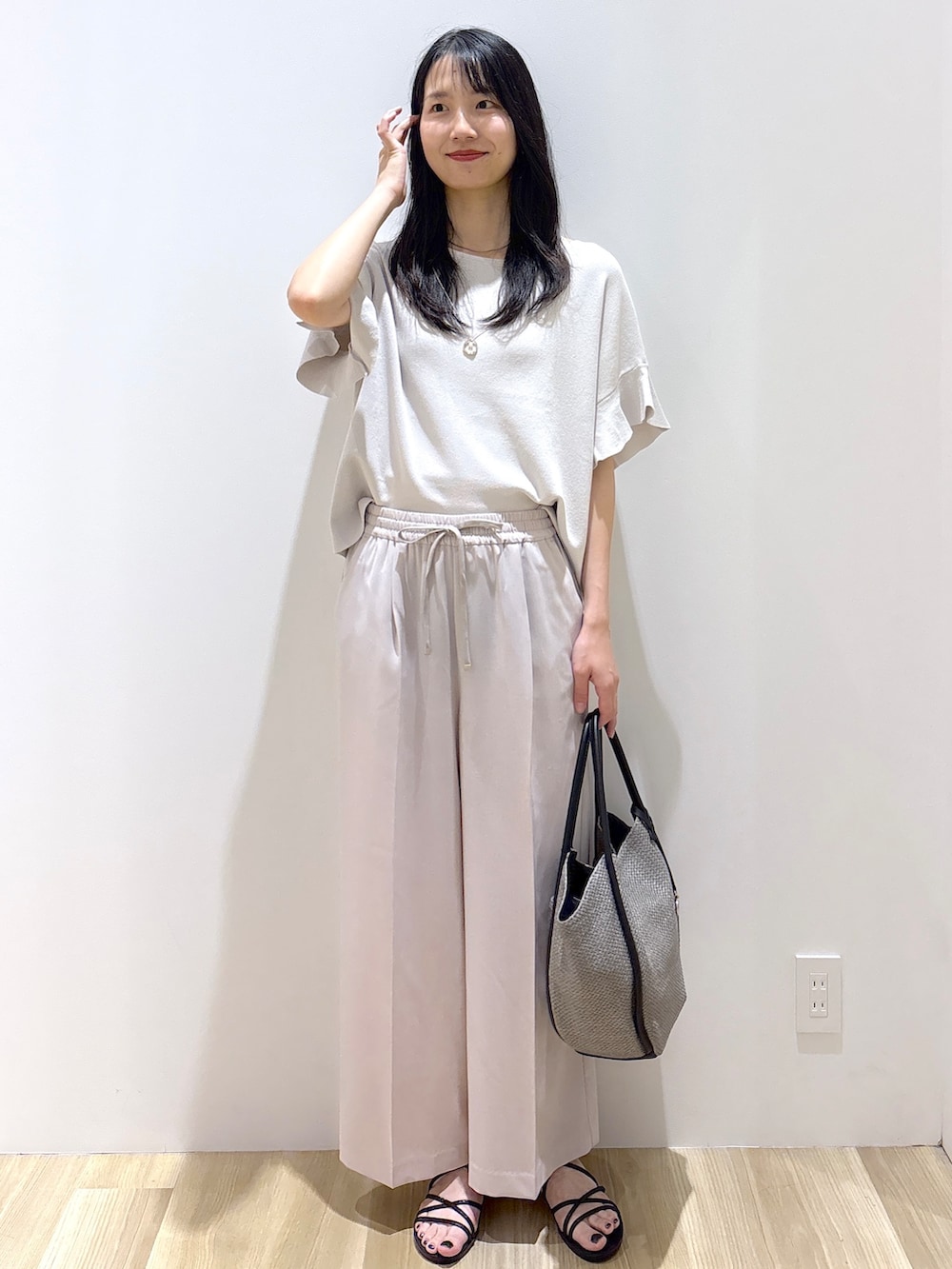 ベージュ系のその他パンツ、ブラック系のサンダル、グレー系のトートバッグを着用したレディースの春コーディネートの2枚目の写真