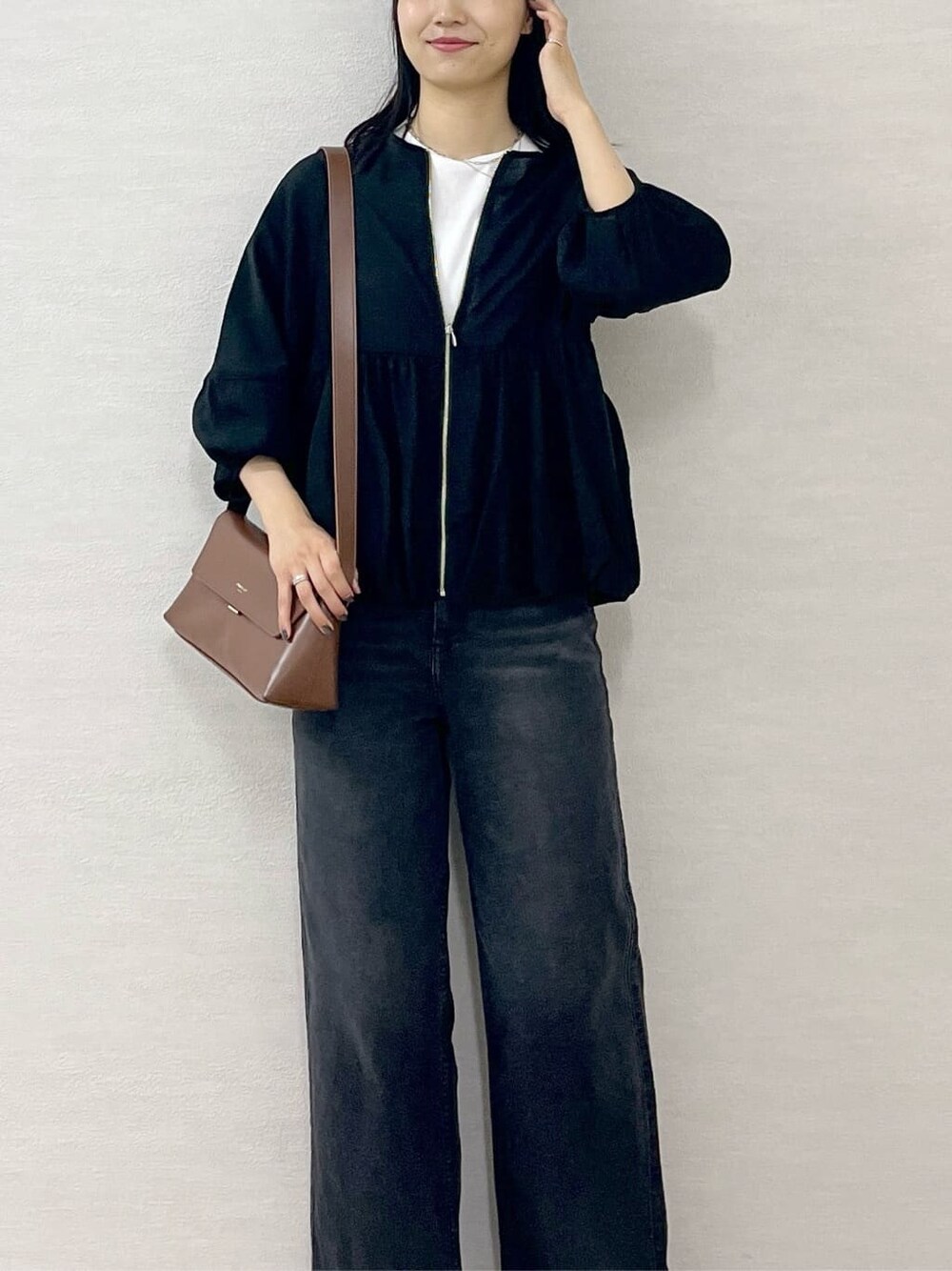 ブラック系のブルゾン、ホワイト系のTシャツ/カットソー、ブラック系のデニムパンツを着用したレディースの夏コーディネートの6枚目の写真