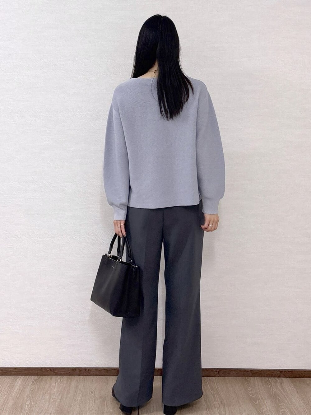 ブルー系のニット/セーター、グレー系のその他パンツ、ブラック系のトートバッグを着用したレディースの冬コーディネートの4枚目の写真