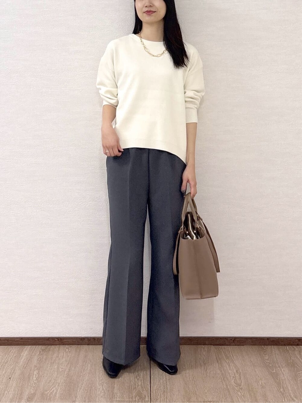 ホワイト系のニット/セーター、グレー系のその他パンツ、ベージュ系のトートバッグを着用したレディースの冬コーディネートの9枚目の写真