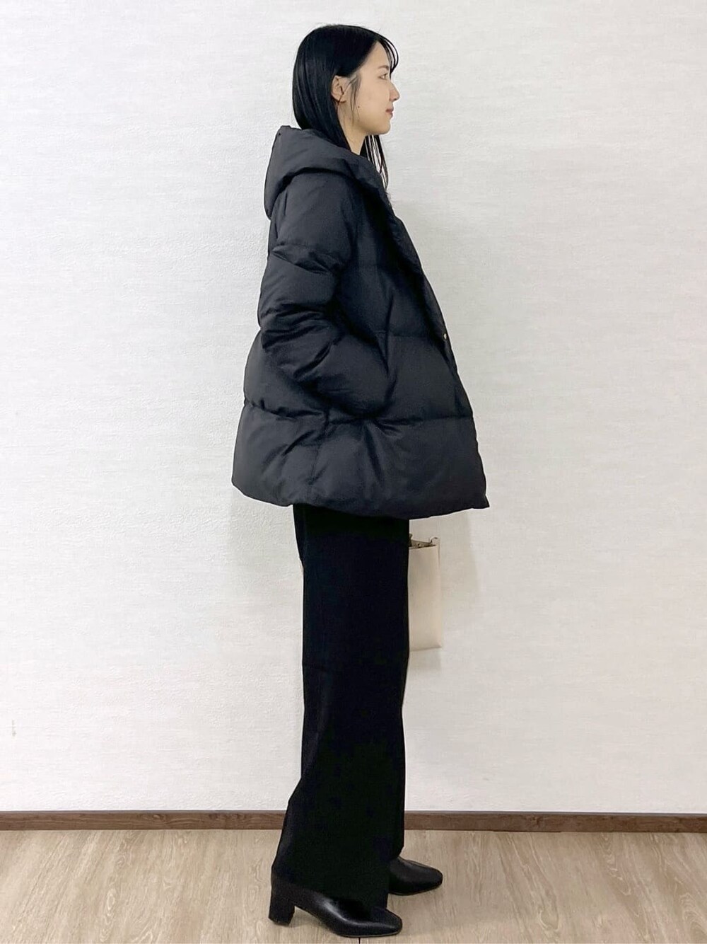 ブラック系のダウンジャケット/コート、ブルー系のニット/セーター、ブラック系のその他パンツを着用したレディースの冬コーディネートの4枚目の写真